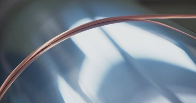 Single copper wire on a spinning metal pipe, macro close up