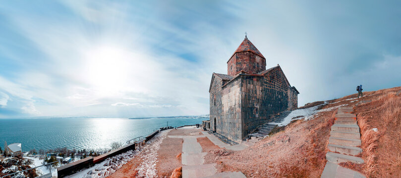 Morning calm panoramic view from the peninsula viewpoint to Sevanavank Monastery overlooking Lake Sevan in sunny weather