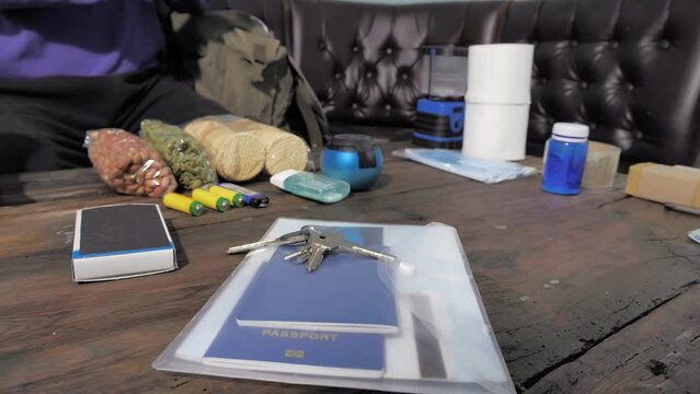 The man is preparing for evacuation and collects essential items. Survival Kit
