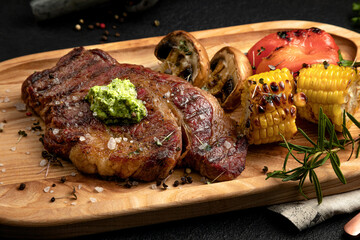 steak served on a wooden tray with grilled vegetables