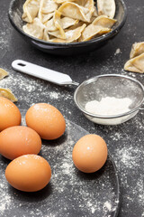 Eggs on a plate and flour in  sieve.