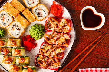 Close up top view of sushi set rolls with cucumber, shrimp tempura, red masago caviar California