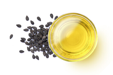 Sesame oil in glass bowl with black sesame seeds isolated on white background. Top view. Flat lay.