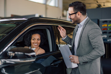 African woman just bought a new car from a car salon, male stuff