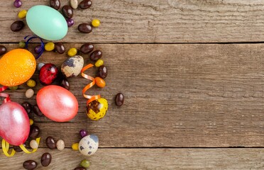Beautiful Easter eggs painted in different beautiful colors on a natural wooden surface. Celebration of Holy Easter.