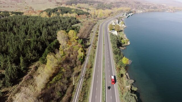 Incredible aerial view of Yerevan-Sevan highway. Travel red tour bus driving on asphalt through pine forest