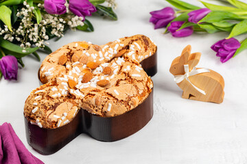 Easter tradition in Italy, Dove Cake topped with icing and almonds.  Colomba di Pasqua. Easter bunny. Spring flowers. Top view.