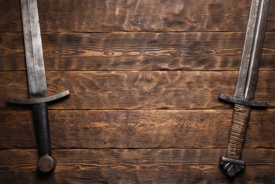 Two ancient sword on the knight table flat lay background with copy space.