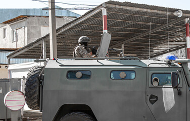 Military operations in Ukraine. A soldier with a machine gun on the roof of an armored personnel carrier. The military repulse the attack of the invaders, hold the defense, capture the terrorists.