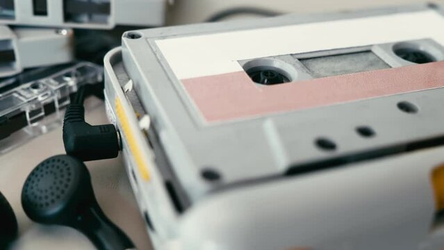 Close up of cassette player with earphones and tapes on the table.