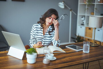 Shot of a young businesswoman looking stressed out while working in an office. Confused...