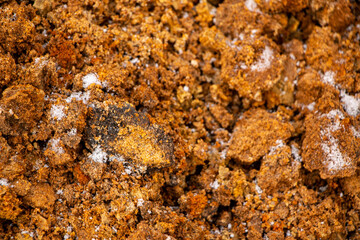 Textural sand, with  relief surface, multi-colored layers and different in size of granules, in outdoor sand career, after mining ore and sand for construction.