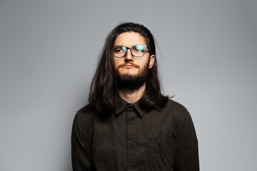 Obraz premium Studio portrait portrait of serious young cute man with long hair.