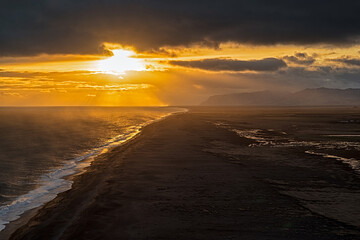 View of the black sand beach from Dyrholaey promontory on Atlantic South Coast at sunset, Iceland