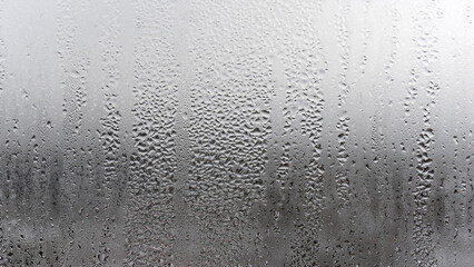 Texture condensation on the glass, outside, bad weather, rain. Steamy window with water drops made in dull day
