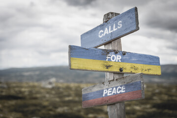 calls for peace text quote on wooden signpost outdoors on nato colored flag, ukrainian flag and russian flag.