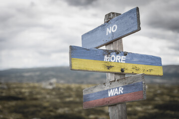 no more war text quote on wooden signpost outdoors on nato colored flag, ukrainian flag and russian...