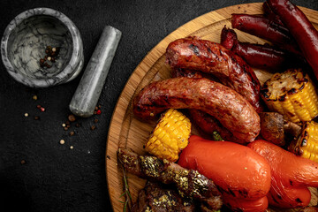 a tray of various grilled products. grilled steak, grilled sausages, grilled vegetables. assorted meat
