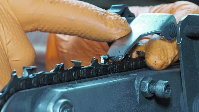 Sharpening chainsaw with abrasive disc from rigth side. Closeup shot