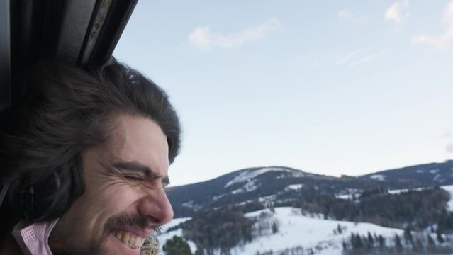 Bearded Male Smiling With Head Out Of Open Window On Train. Slow Motion, green sustainable travel concept