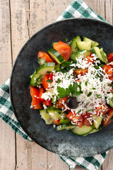 Traditional Bulgarian shopska salad with tomato,cucumber and bulgarian sirene cheese on wooden table