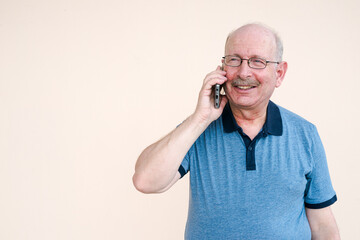 Portrait of happy senior man using mobile phone while talking