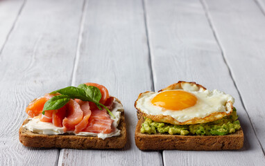 Background from sandwiches with smoked salmon, cream cheese, avocado and fried egg.