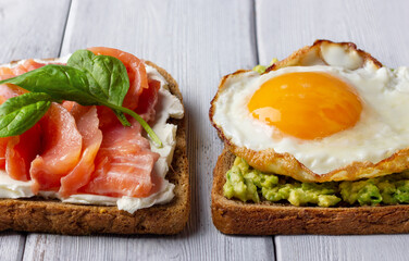 Background from sandwiches with smoked salmon, cream cheese, avocado and fried egg. Concept for healthy nutrition.
