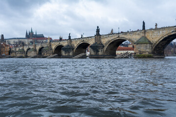 Fototapeta premium The famous Carles-Bridge in Prague on a cold winter day with a dramatic sky
