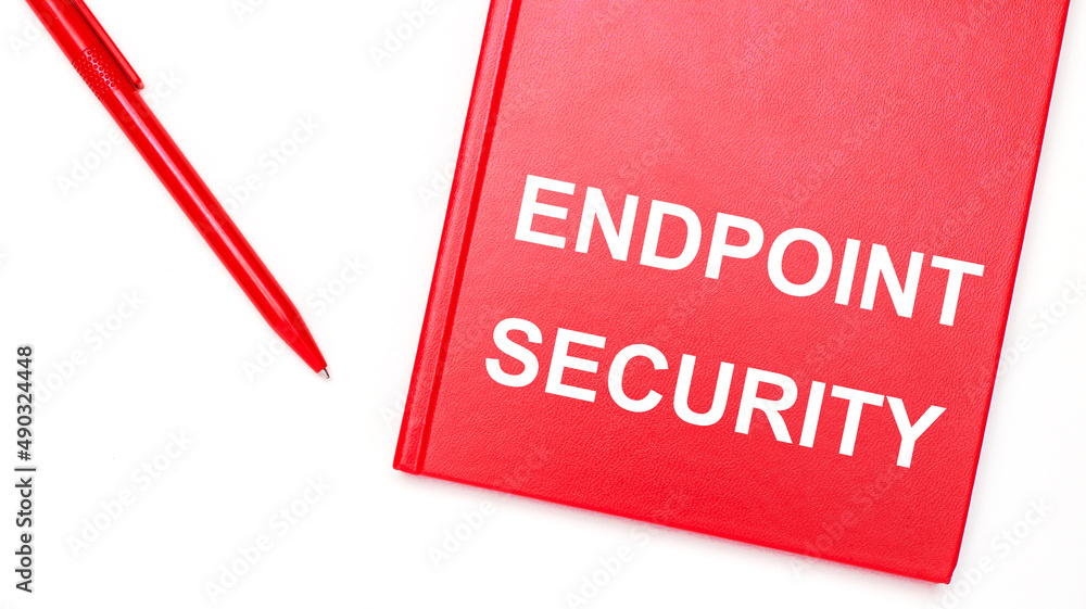 Poster the text endpoint security is written on a red notepad near a red pen on a white table in the office