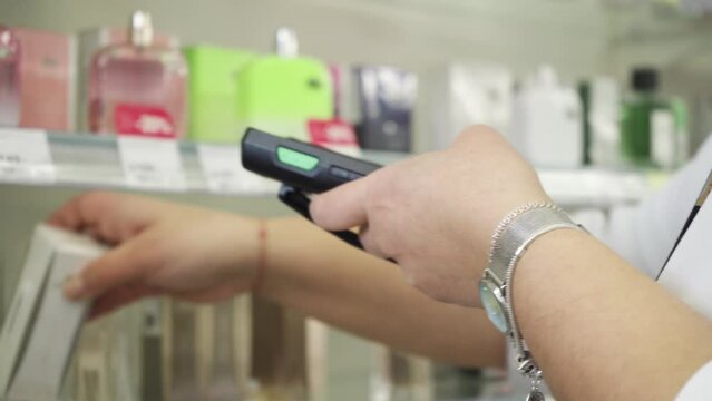 A female sales associate holding a barcode scanner device for lowering prices on merchandise