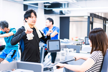 Obraz premium ジムでトレーナーの指導を受ける若い女性