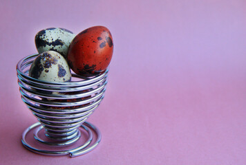 red and white quail eggs on a pink background