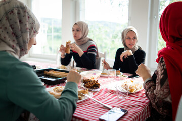 Muslim family and friends gathering together at home for eating dinner. High quality photo