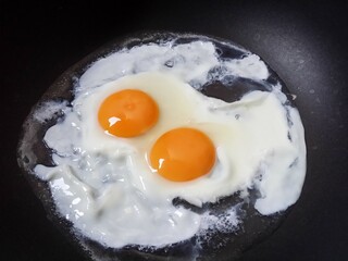 2 fried eggs in a frying pan