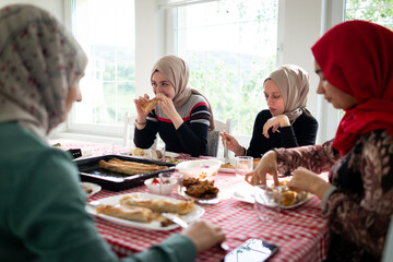Muslim family and friends gathering together at home for eating dinner. High quality photo
