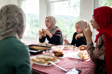 Muslim family and friends gathering together at home for eating dinner. High quality photo