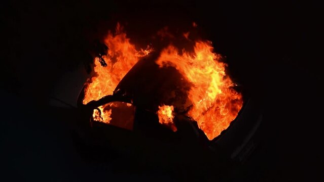 Car burning in fire explosion blast during war attack at night.