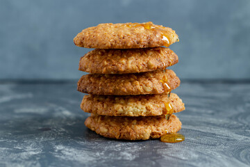 Peanut cookies with honey stack on a gray background