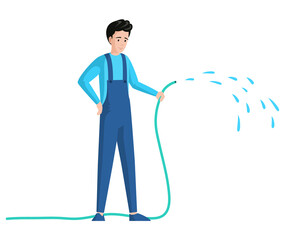 Young man sprinkling with water from hose isolated on white background. Gardener or worker in jumpsuit with hosepipe. Guy cares for garden. Male character holding garden hose to water plant