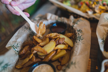 Tenedor pinchando patatas gajo en una mesa de madera