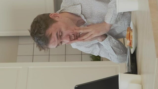 Vertical Video. Tired Male Freelancer Overwhelmed with Job, Using Laptop All Night Long. Drinking from Coffee Pot