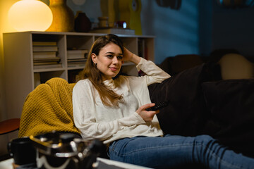 woman relaxing at home and watching television