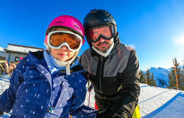 Fototapeta na wymiar Family enjoying winter vacations taking selfie in skiing gear.