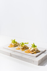 Tostadas de queso de cabra con miel de abeja sobre mármol. Aperitivo comida mediterránea sobre fondo claro	