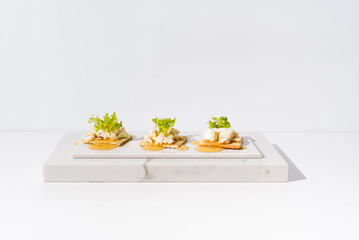 Tostadas de queso de cabra con miel de abeja sobre mármol. Aperitivo comida mediterránea sobre fondo claro	