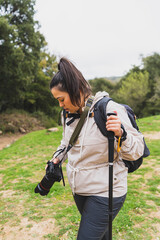 Chica joven guapa realizando senderismo por ruta verde en andalucia equipada con ropa deportiva y...