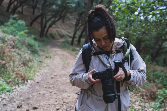 Mujer tomando fotos en paraje natural realizando senderismo