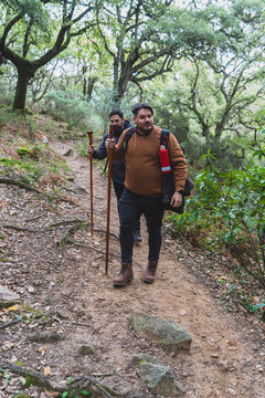 Dos chicos con palo de andar por sendero de ruta verde 