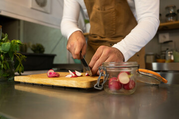Hands of the cook cutting radish in his food truck. Copy space. 